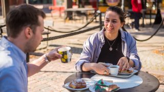 Young women and man having coffee outside in a café.